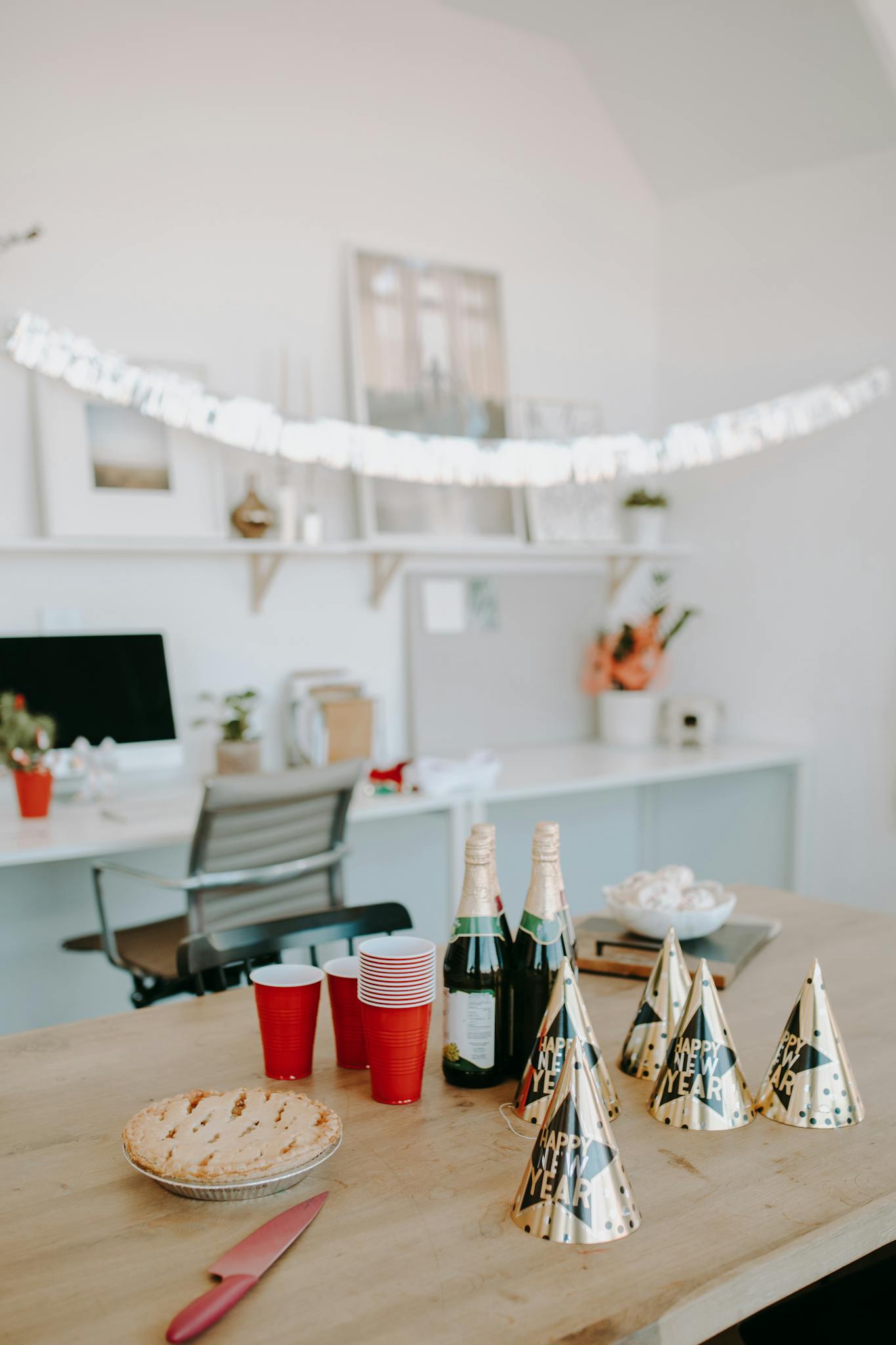 A cheerful office party setup with New Year decorations, snacks, and sparkling beverages.