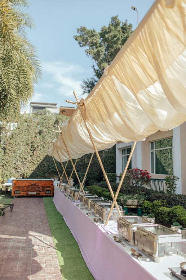 Charming outdoor buffet arrangement under canopy at garden event, perfect for weddings or celebrations.